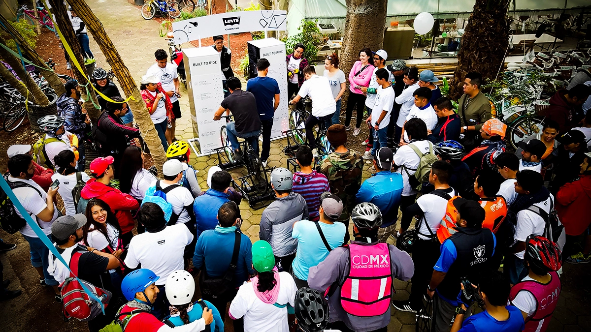 Participante pedaleando frente a una pantalla que muestra su posición y distancia en tiempo real durante un evento