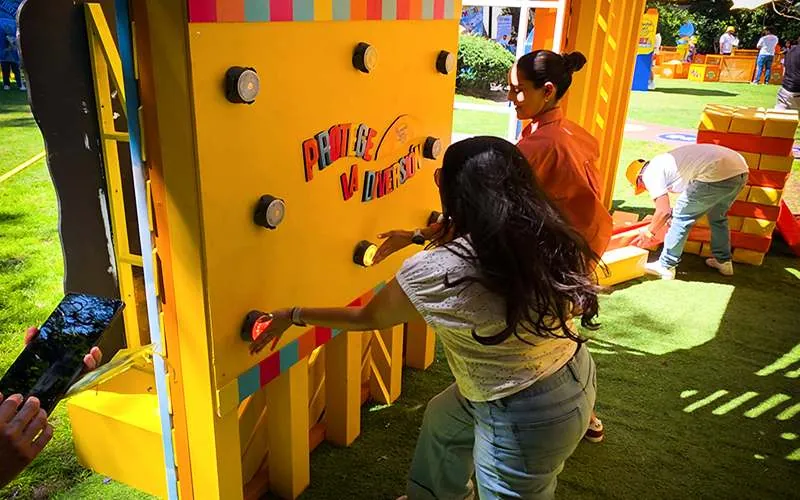 Participante golpeando los objetivos luminosos de un muro de reflejos en una activación al aire libre